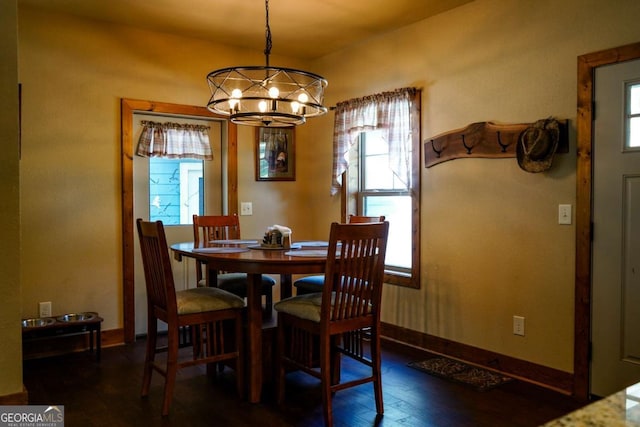 dining room with dark hardwood / wood-style floors and a chandelier