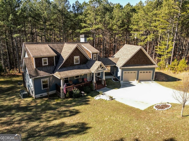 view of front facade with cooling unit, a garage, a front yard, and covered porch