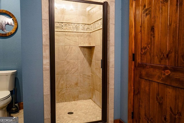 bathroom with a shower with door and toilet