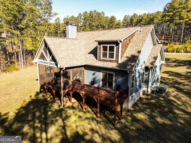 view of front of house featuring a wooden deck, central AC, a front yard, and a sunroom