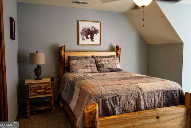 carpeted bedroom with ceiling fan and vaulted ceiling