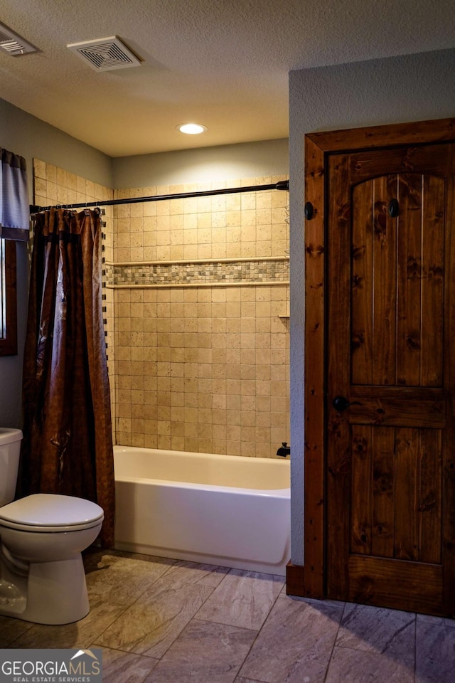 bathroom with shower / bath combo, toilet, and a textured ceiling