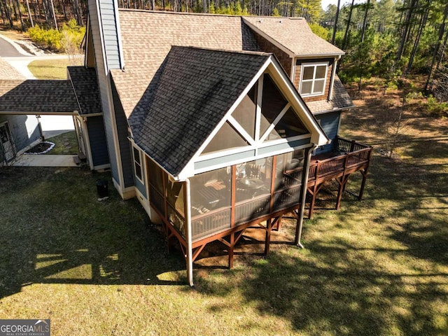 view of outdoor structure featuring a sunroom and a lawn