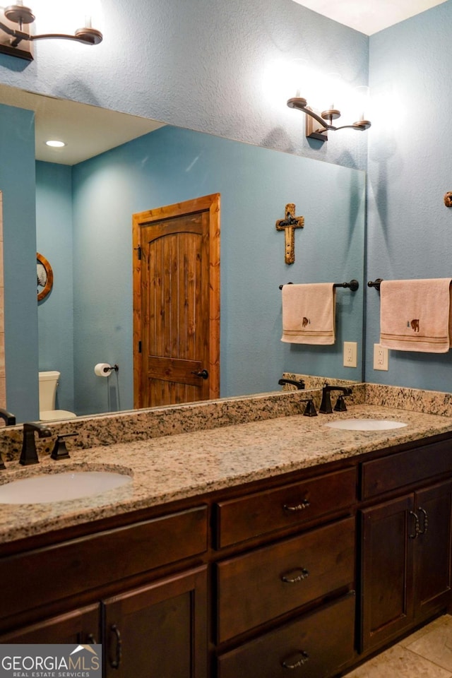 bathroom with tile patterned flooring, vanity, and toilet