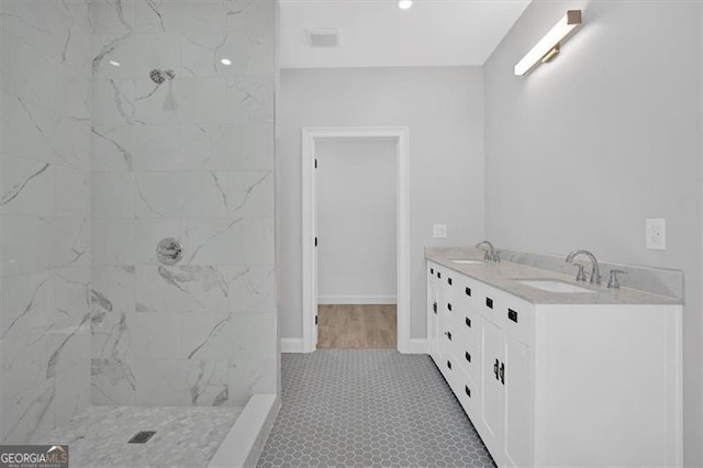 bathroom with vanity and a tile shower