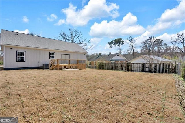 back of house featuring central AC, a wooden deck, and a lawn