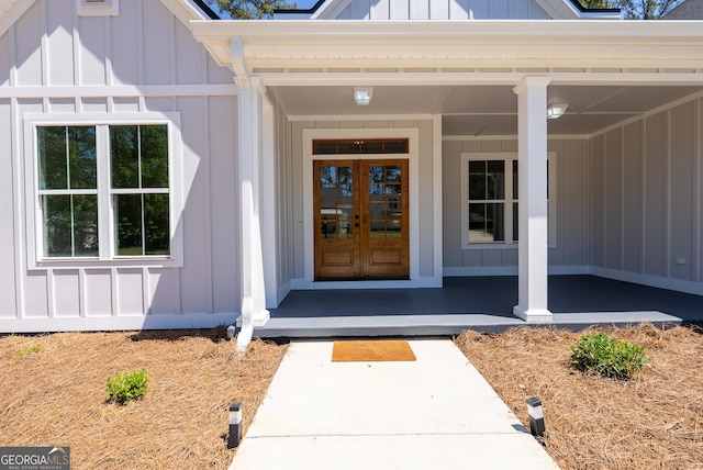 doorway to property with board and batten siding, french doors, and covered porch