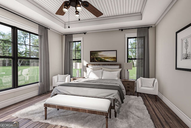 bedroom featuring a tray ceiling, multiple windows, and wood finished floors