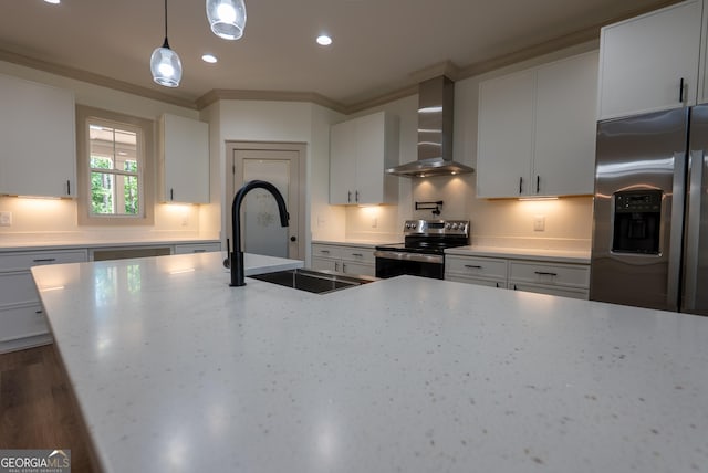kitchen with appliances with stainless steel finishes, wall chimney range hood, a sink, decorative light fixtures, and recessed lighting