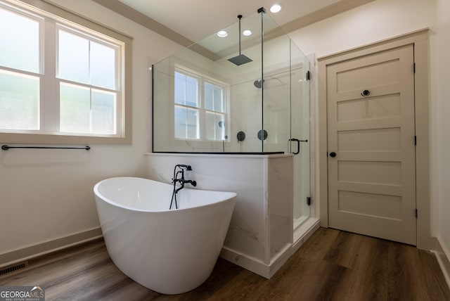 bathroom with a shower stall, healthy amount of natural light, a freestanding tub, recessed lighting, and baseboards