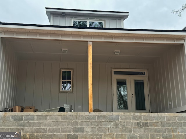 view of exterior entry featuring visible vents and board and batten siding