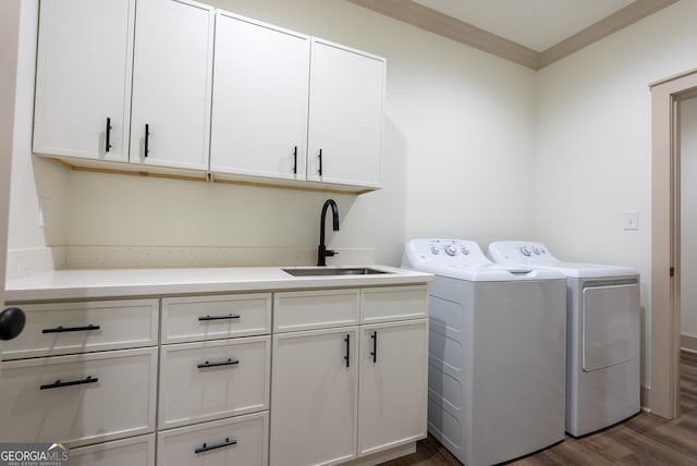 laundry room featuring washing machine and dryer, dark wood-style floors, crown molding, and cabinet space