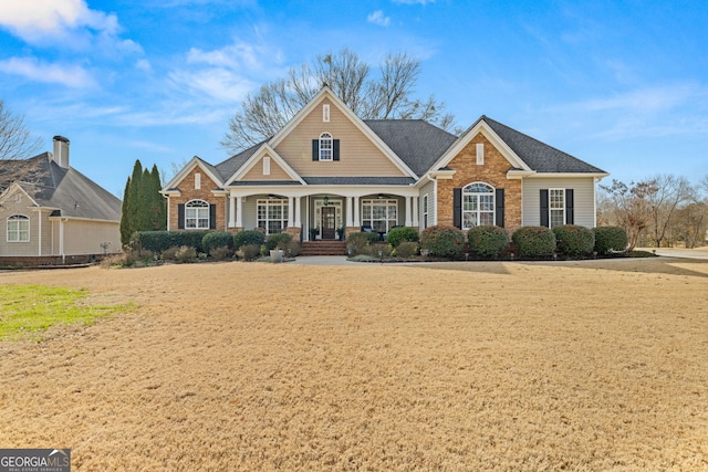 craftsman inspired home with covered porch and brick siding