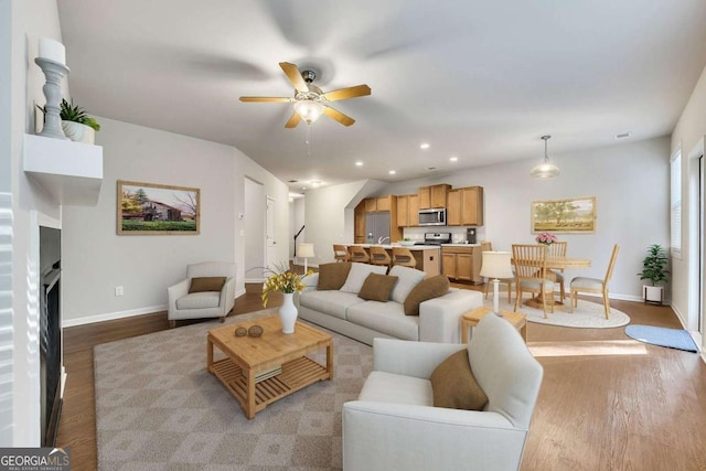 living room featuring light hardwood / wood-style flooring and ceiling fan