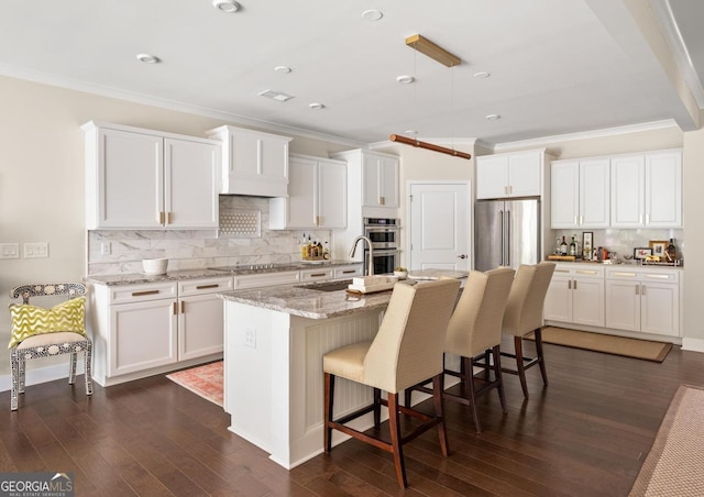 kitchen with white cabinetry, stainless steel appliances, dark hardwood / wood-style flooring, and a kitchen island with sink