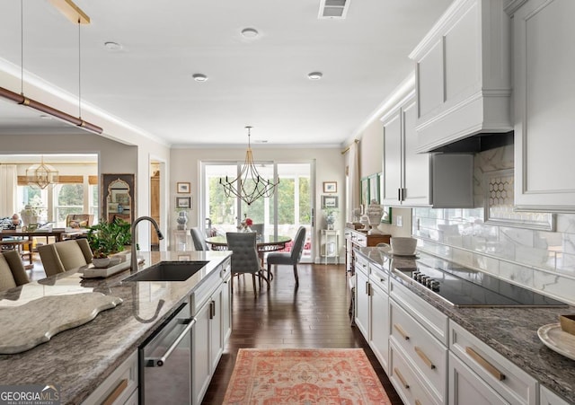 kitchen with dark stone countertops, sink, and white cabinets