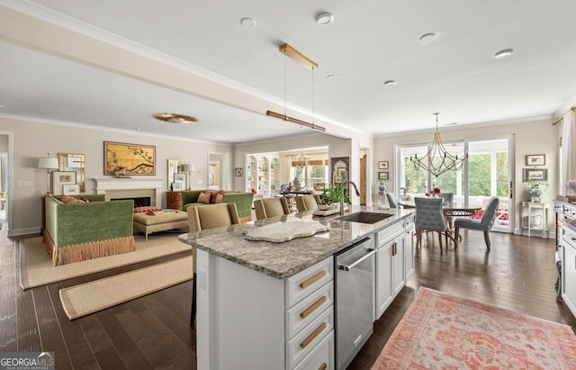 kitchen featuring dishwasher, light stone countertops, a kitchen island with sink, and decorative light fixtures