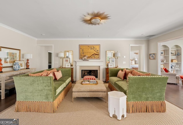 living room with crown molding, wood-type flooring, and built in features