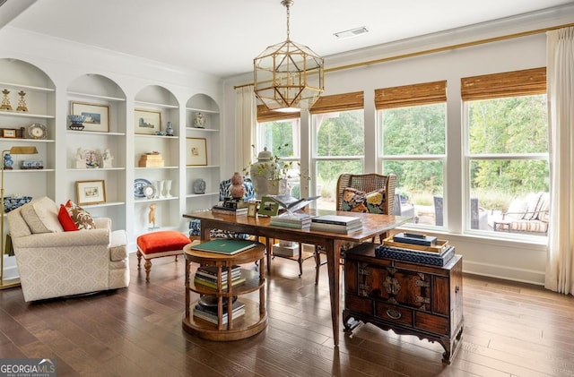 interior space featuring hardwood / wood-style flooring, ornamental molding, a wealth of natural light, and an inviting chandelier