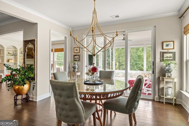 dining area with an inviting chandelier, ornamental molding, and dark hardwood / wood-style floors