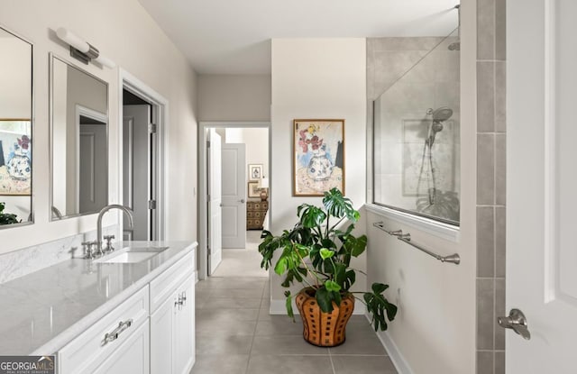 bathroom featuring vanity, a tile shower, and tile patterned floors