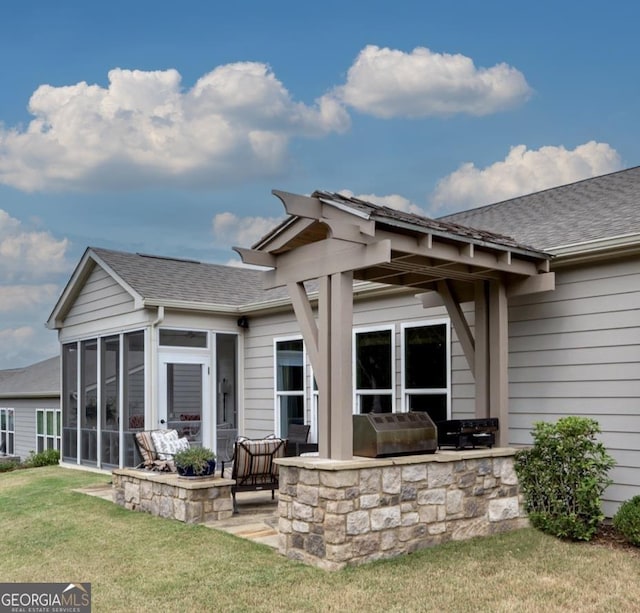 rear view of house with a sunroom, area for grilling, a patio area, and a lawn