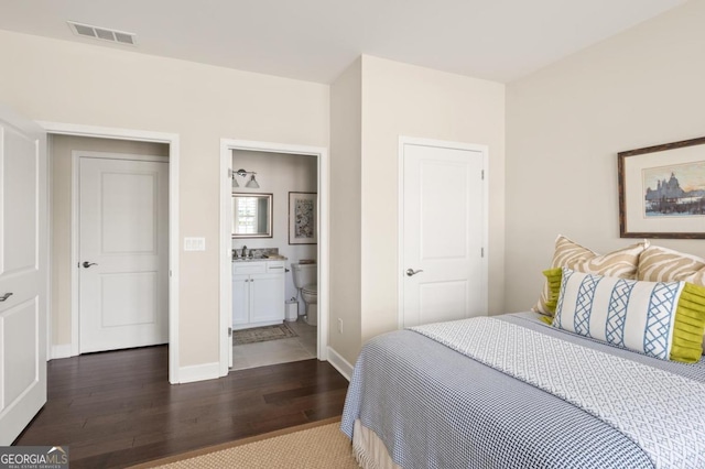 bedroom featuring ensuite bath, dark hardwood / wood-style floors, and sink