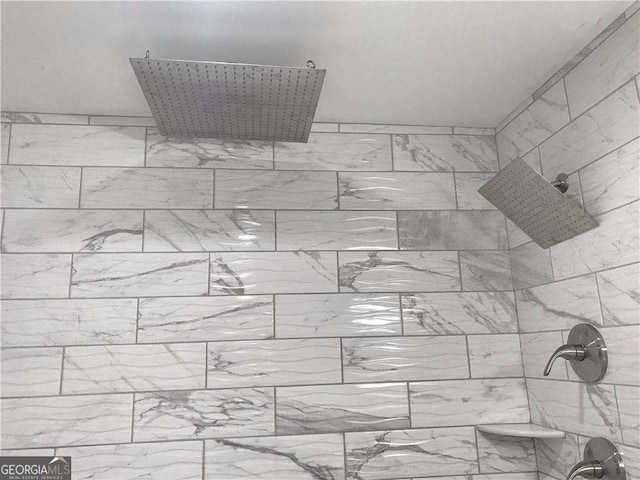 interior details featuring a tile shower