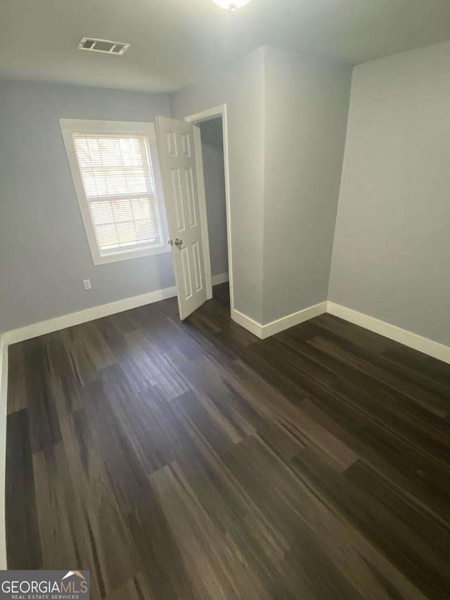 unfurnished bedroom featuring dark hardwood / wood-style flooring