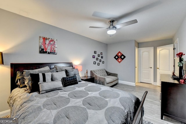 bedroom featuring light wood-type flooring, a ceiling fan, and baseboards