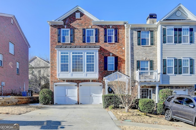 townhome / multi-family property with an attached garage, a chimney, concrete driveway, and brick siding