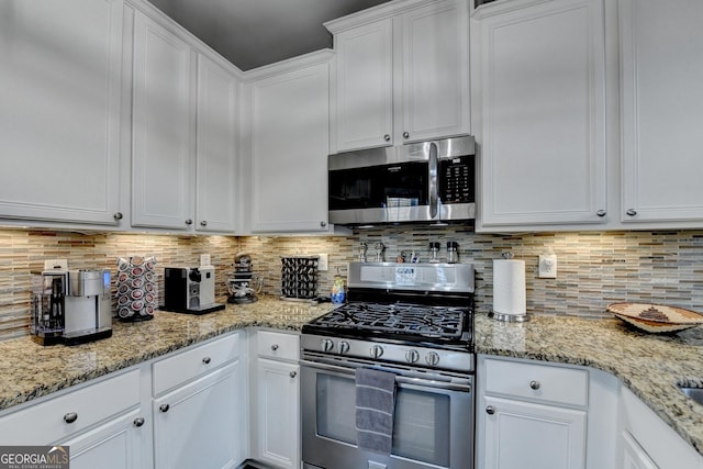 kitchen featuring white cabinets, tasteful backsplash, light stone counters, and stainless steel appliances