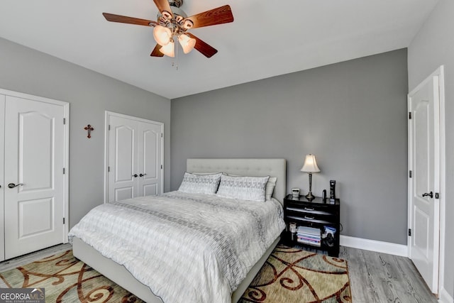 bedroom with light wood finished floors, a closet, a ceiling fan, and baseboards