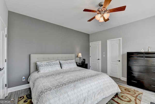 bedroom featuring wood finished floors, a ceiling fan, and baseboards