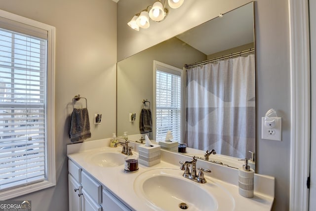 bathroom featuring double vanity, a shower with shower curtain, and a sink