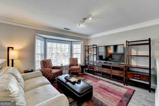 living area with light wood-style floors, rail lighting, visible vents, and ornamental molding