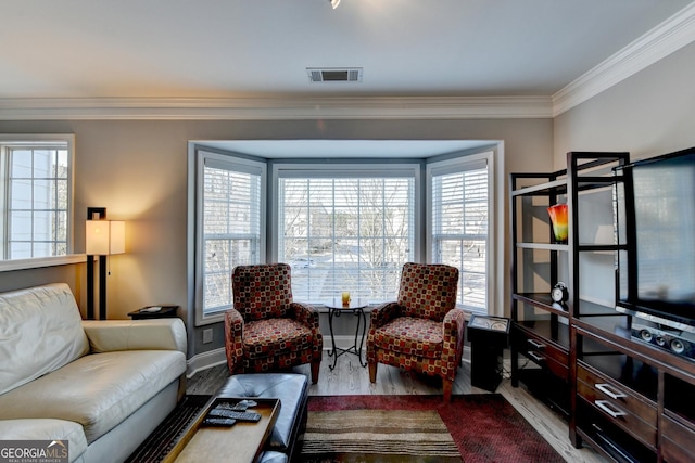 living room with light wood-type flooring, baseboards, visible vents, and ornamental molding