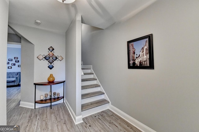 staircase with baseboards and wood finished floors