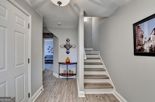 stairs with baseboards and wood finished floors