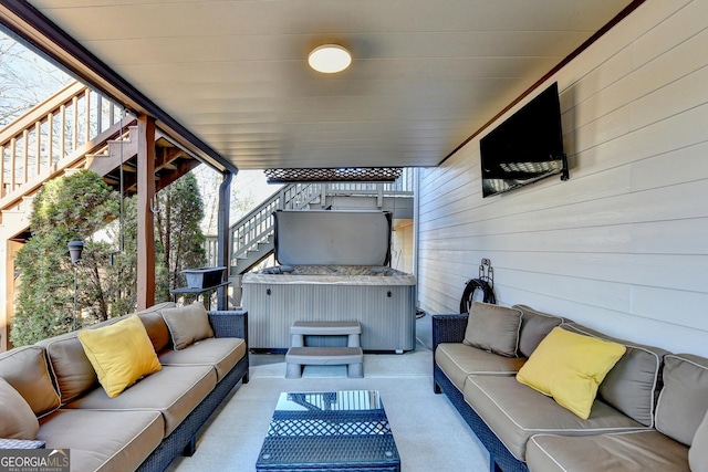 view of patio / terrace with stairway, an outdoor living space, and a hot tub