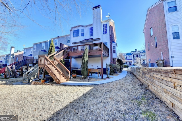 rear view of house with stairs, central AC, a chimney, and a wooden deck