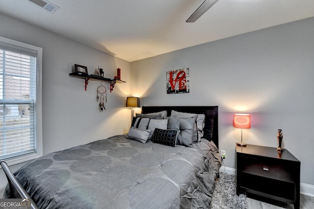 bedroom with a ceiling fan, visible vents, and baseboards