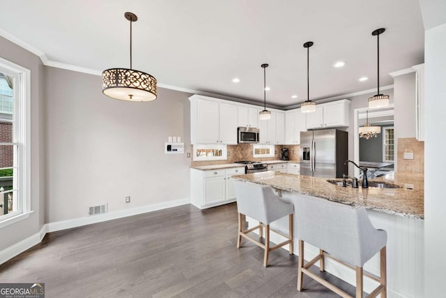 kitchen featuring appliances with stainless steel finishes, crown molding, sink, white cabinetry, and kitchen peninsula