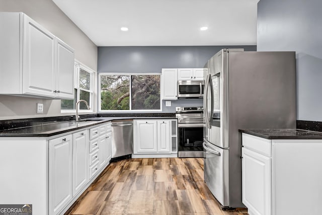 kitchen featuring white cabinetry, stainless steel appliances, light hardwood / wood-style floors, and sink