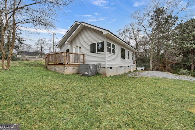 rear view of property featuring central AC unit, a lawn, and a deck