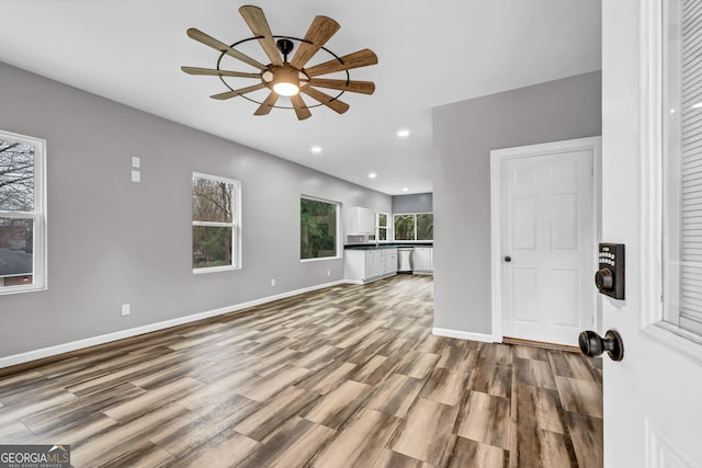 unfurnished living room featuring wood-type flooring and ceiling fan