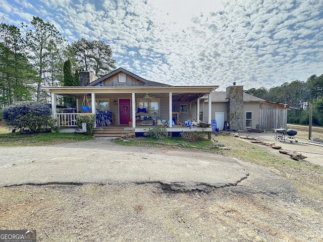 view of front facade featuring a porch and a chimney