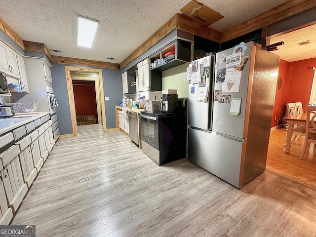 kitchen with light wood finished floors, light countertops, appliances with stainless steel finishes, and a textured ceiling