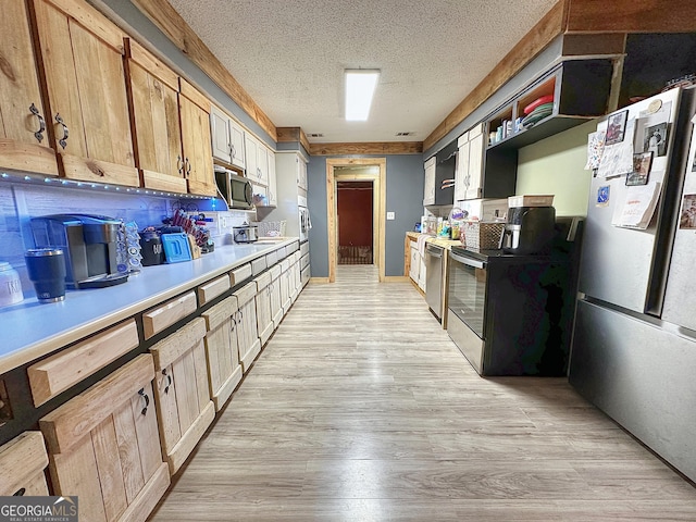 kitchen featuring a textured ceiling, light wood-style flooring, stainless steel appliances, visible vents, and light countertops