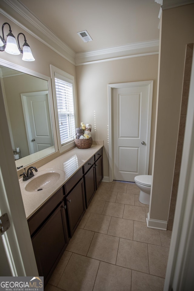 bathroom with tile patterned floors, toilet, vanity, and crown molding